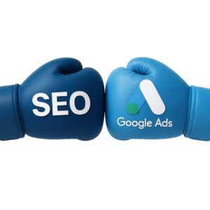 SEO vs Google Ads в 2025: две боксерские перчатки с логотипами на белом фоне — визуал сравнения каналов продвижения